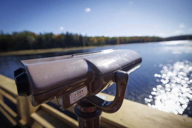 Binoculars on an deck overlooking a lake