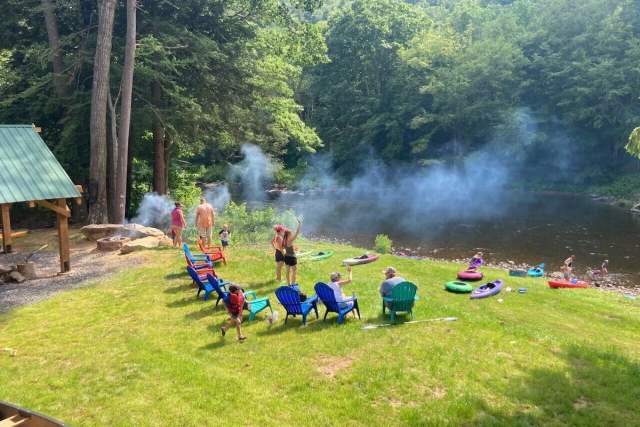 People standing and sitting in chairs along a river