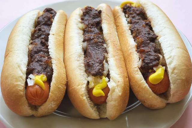 Three chili cheese dogs on a plate