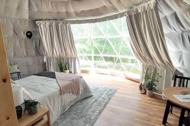 Interior of a dome with a bed, curtain, and room decor