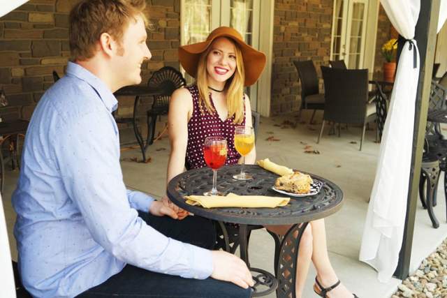 Couple sitting on porch enjoying wine and snacks