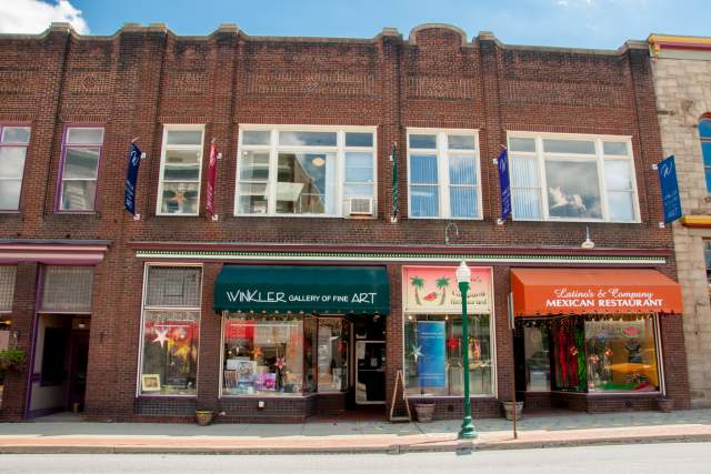Exteriors of various brick storefronts on a Main Street