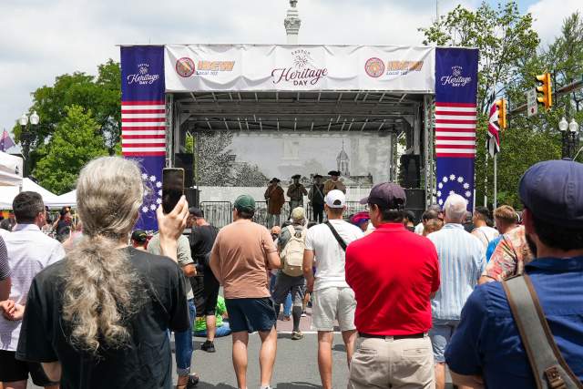 A crowd of people standing in front of a stage watching live entertainment