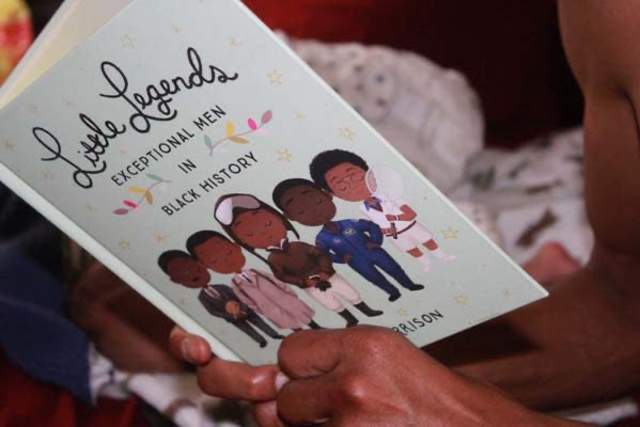 Person holding open and reading a book called "Little Legends"