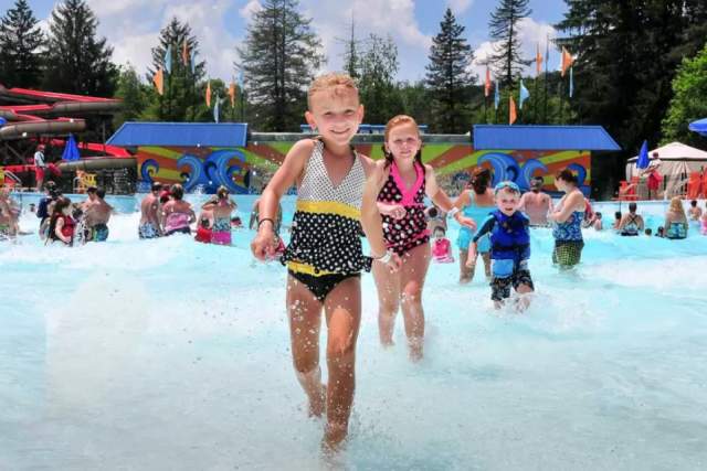 Young kids running and playing in a wave pool at a Idlewild and SoakZone waterpark in the Laurel Highlands