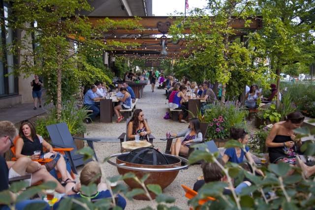 People sit outside at a beer garden enjoying beverages