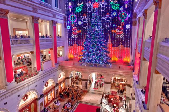 Christmas display with a lit Christmas tree overlooking a two-story department store