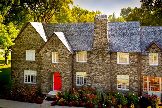 Exterior of a two story mansion with a bright red door as the entrance