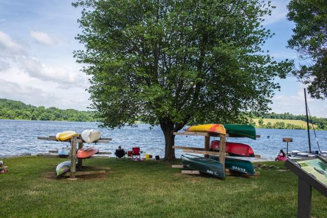 Canoes resting on shelves in front of a lake