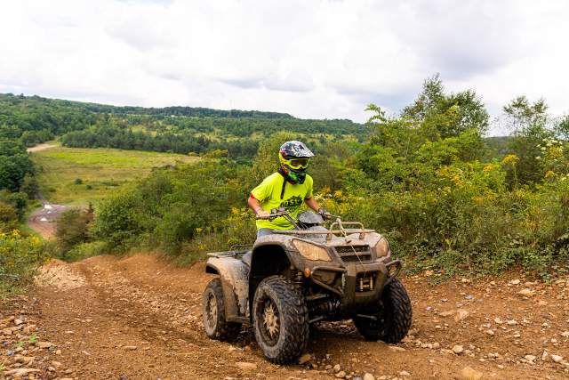 A person riding ATV thru rocky trail with Helmet on