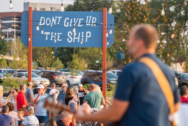 Man plays guitar to a crowd outside