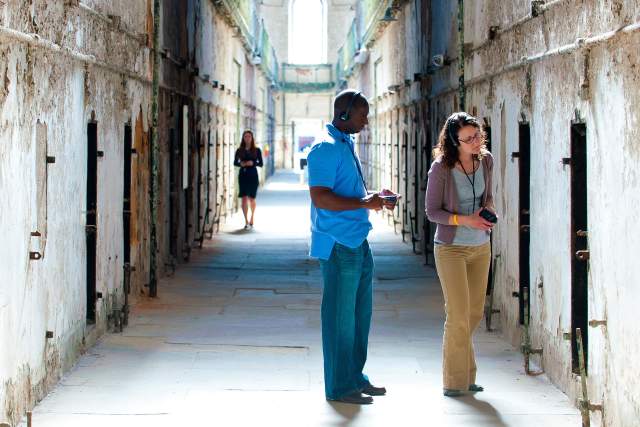 A man and a woman on a tour in an old jail in Philadelphia