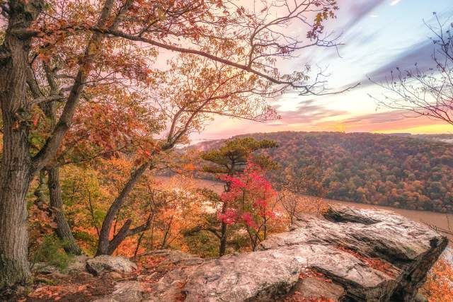 An overlook over a body of water surrounded by vibrant fall foliage