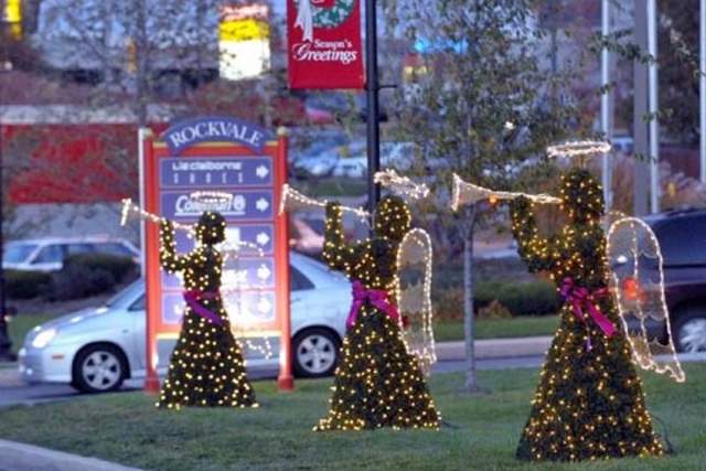Three angel statues with holiday lights all blowing decorative trumpets on display in front of The Shops at Rockvale in Lancaster