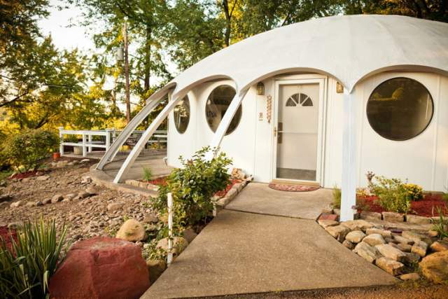 A white, circular house with a curved roof