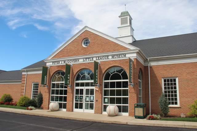 Exterior of a museum with writing on the building that reads Peter J. McGovern Little League Museum