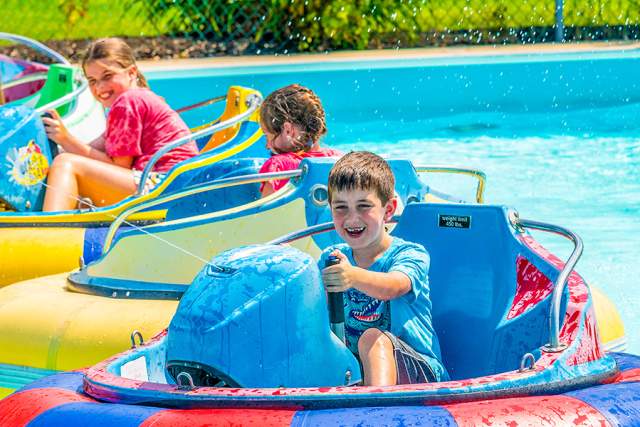 Young kids on floating devices in a pool
