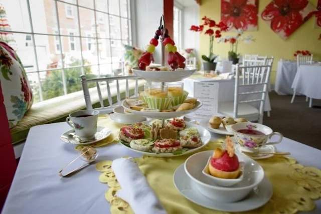 Desserts and tea set on a table in front of a window
