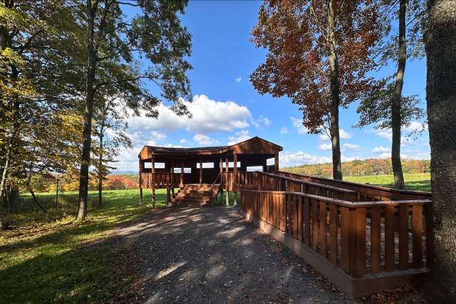 An outdoor ramp leading up to a small pavilion-lookout in the wood