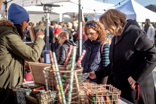 Two women shopping at a street vendor at the Kennett Holiday Village Market in Kennett Square