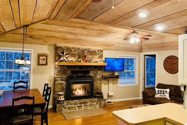 Interior of a wooden cabin with a lit fireplace and a dining table