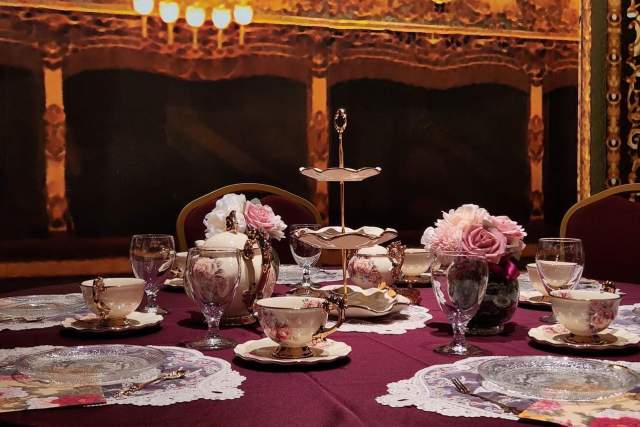 Tea cups and nice plates set on a red table cloth for tea time at the Marilyn Horne Museum and Exhibit Center