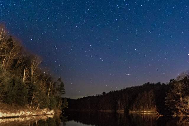 A starry night with the orion constellation above Raystown Lake in Huntingdon County