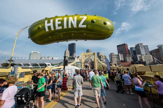 A giant pickle float and crowd at the Picklesburgh festival in downtown Pittsburgh