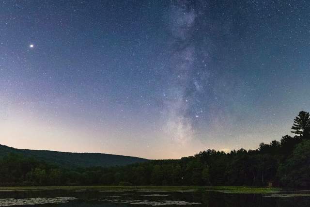 A starry night overtop of a lake