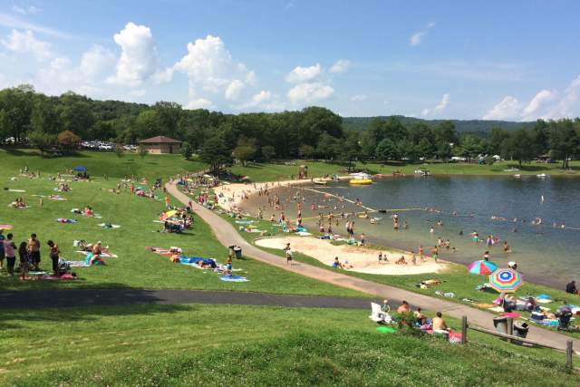 People on sunbathing on the shores of Raystown Lake