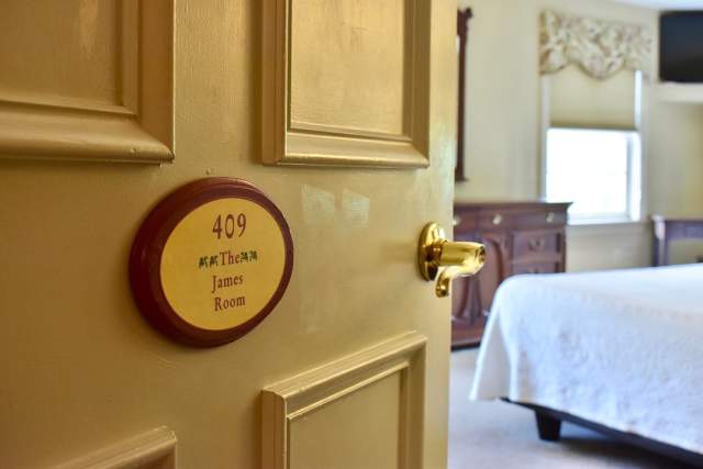 A bedroom door with a plaque on the front that reads 409 The James Room