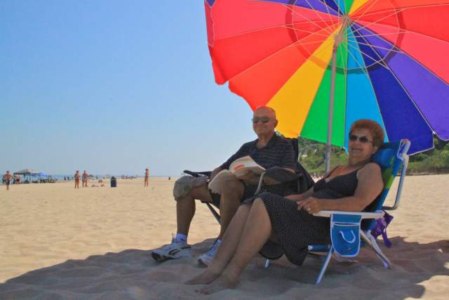 Couple under umbrellas at the beach