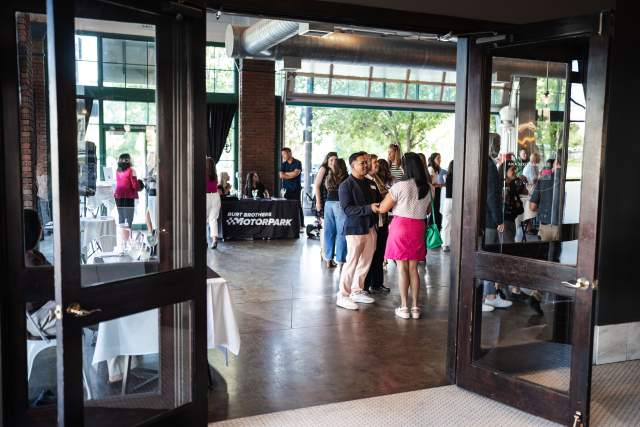 Two open glass french doors. Through them you can see people smiling and talking to each other.