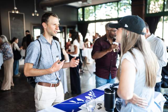 Man interacting with vendors at their table at Cucina Toscana Partner networking event