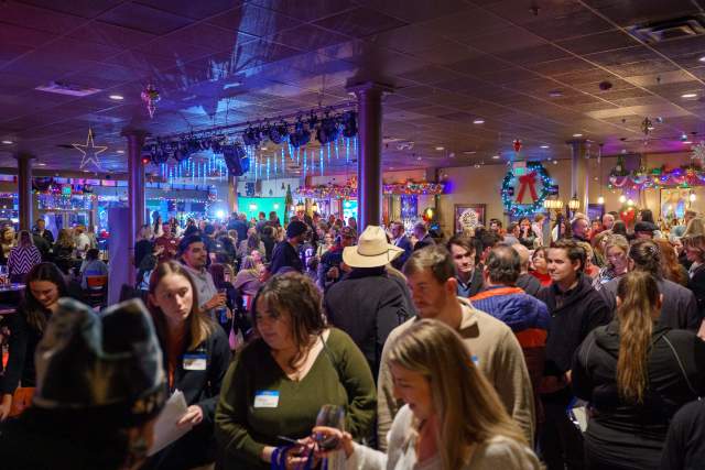 View of a crowded bar. Everyone has name tags on so it is clear they are there for an event.