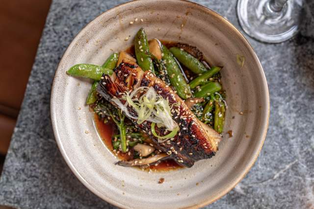 Plate of Fish with sugar snap peas and sauce at Franklin Ave Cocktails & Kitchen