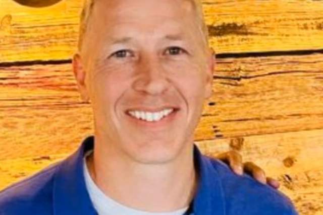 Smiling man in medim blue polo shirt