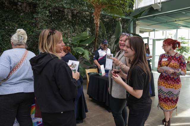 People talking and laughing in what looks like a large indoor garden space