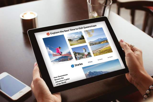 Person holding ipad featuring Destination Queenstown website