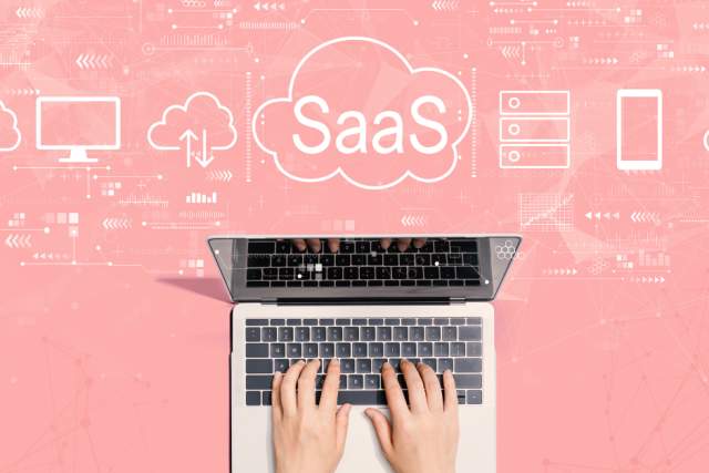 SaaS Blog Stock Image | Laptop with hands and SaaS graphics