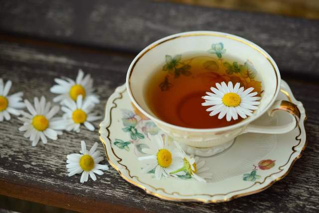 A cup of tea with a flower floating in it.
