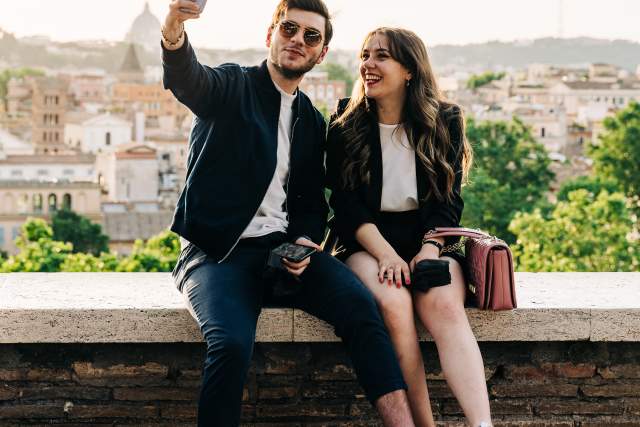 Young couple taking a selfie during golden hour in the Giardino degli Aranci in Rome, Italy
