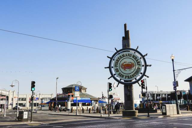 A sign at the entrance of Fisherman's Wharf on a sunny day in San Francisco.