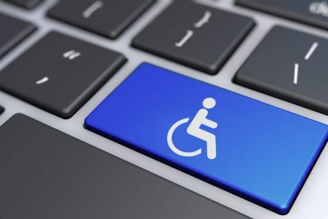 Close-up of a keyboard with a blue key featuring a wheelchair accessibility symbol.