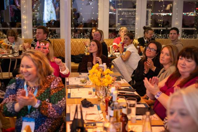 Attendees of Simpleview EMEA Summit smile and cheer on winners at the awards reception.