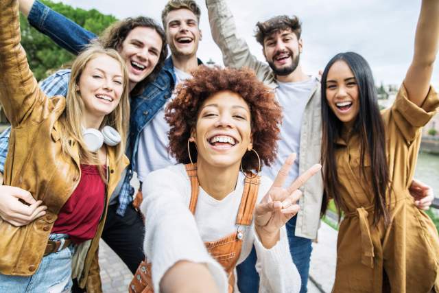 A group of friends pose for a selfie together while traveling.