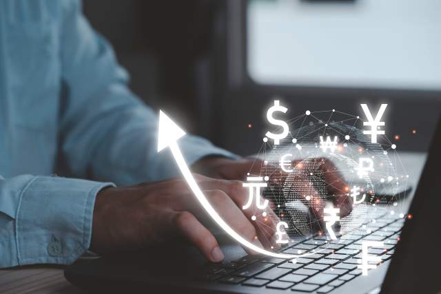 Person using a smartphone with glowing currency icons, symbolising digital monetisation opportunities.