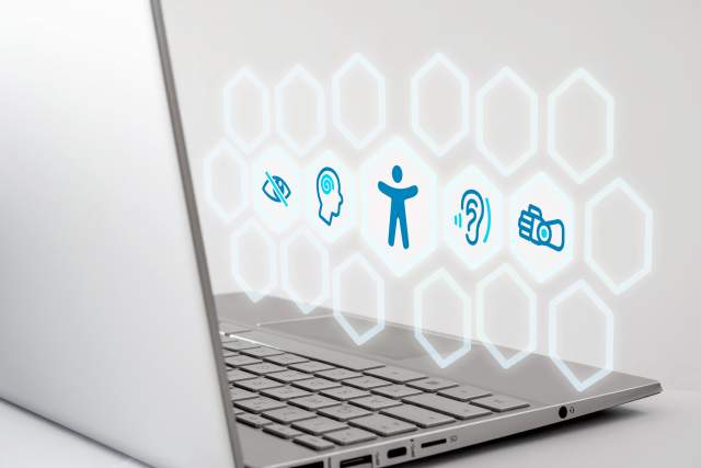 Laptop displaying web accessibility icons representing visual, auditory, and motor support, reflecting how destination marketers can simplify accessibility challenges into practical solutions.