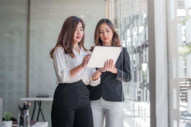 Two professionals review destination information on a digital tablet, reflecting how technology is shaping meeting planning decisions.