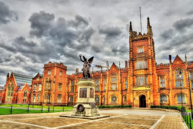 A statute stands in front of a university in Belfast.